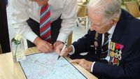 Harry Patch signing a map of Ypres - click for larger image